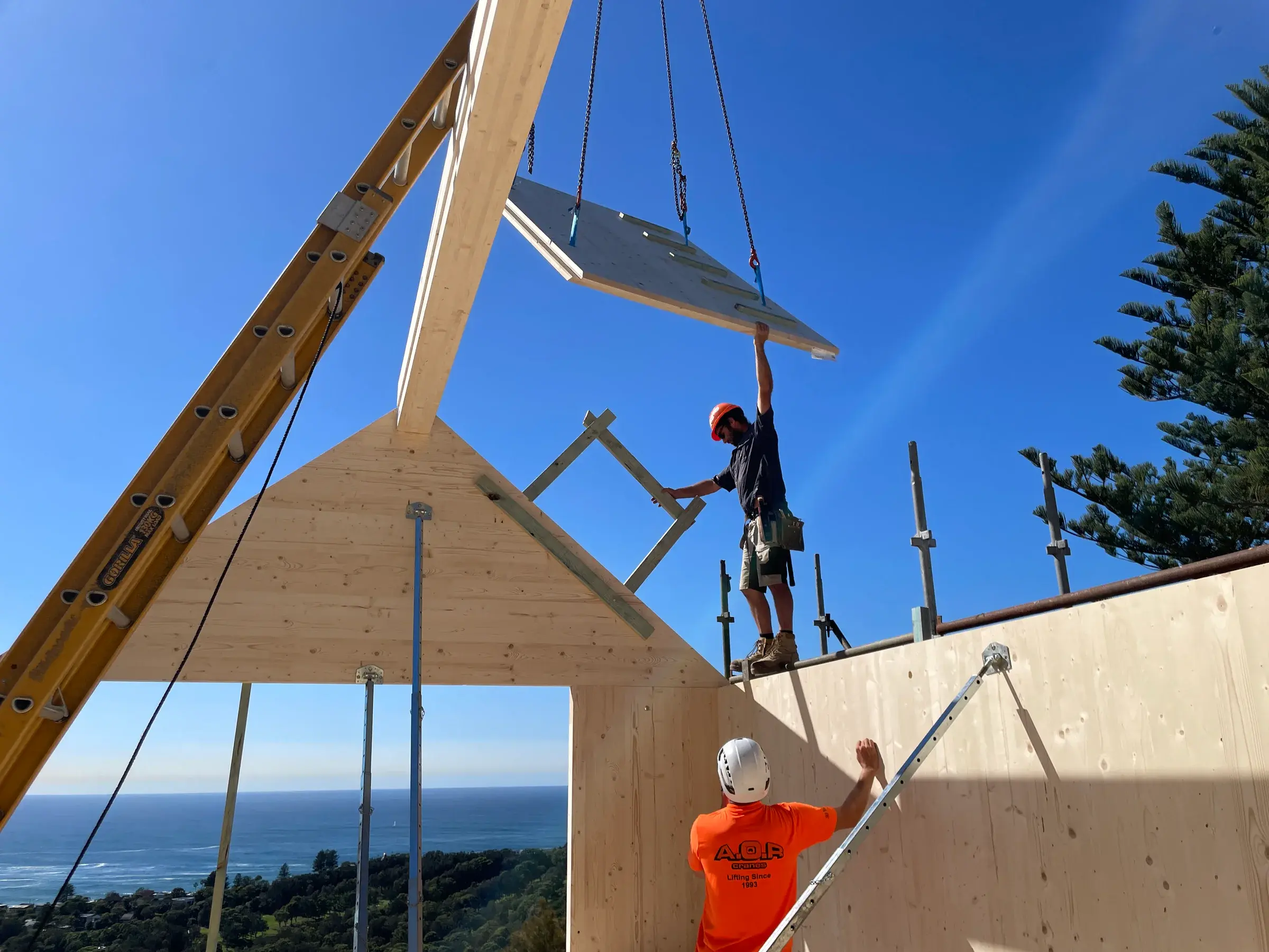 Pracovníci počas montáže strešného CLT panelu na stavbe Bilgola Plateau